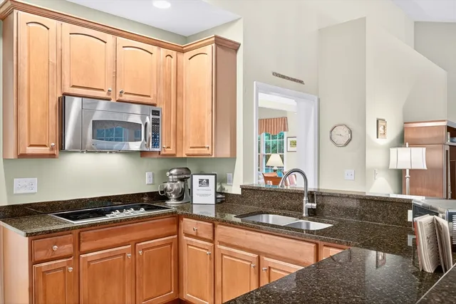 a kitchen with stainless steel appliances granite countertop a stove a sink and a microwave