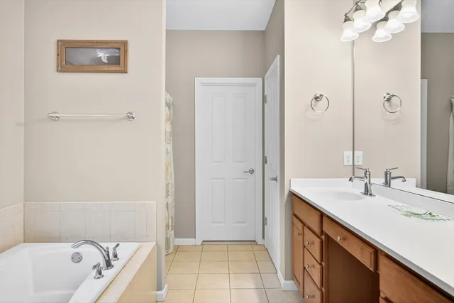 a bathroom with a tub sink and mirror