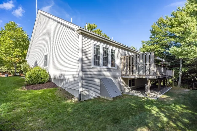 a view of a house with a wooden deck and a yard