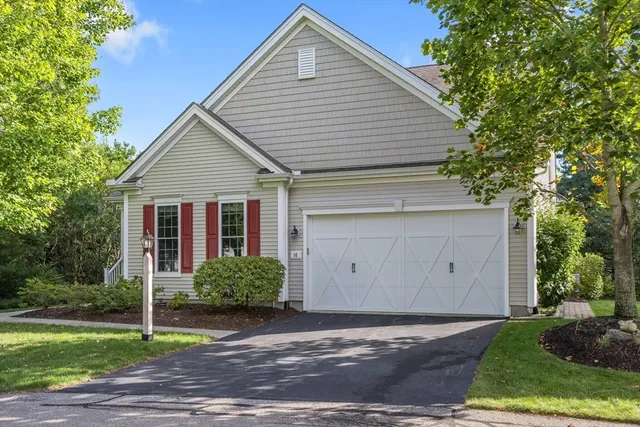 a view of a house next to a yard and large tree