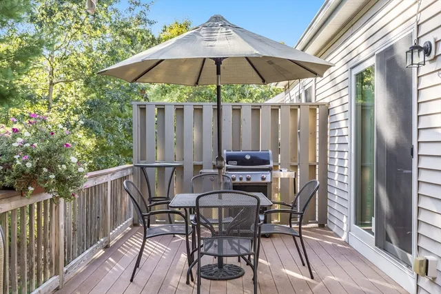 a patio with wooden floor a yard a table and chairs