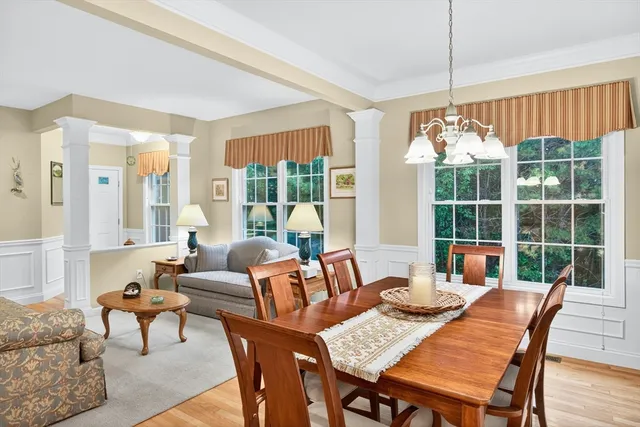 a dining room with furniture a chandelier and wooden floor