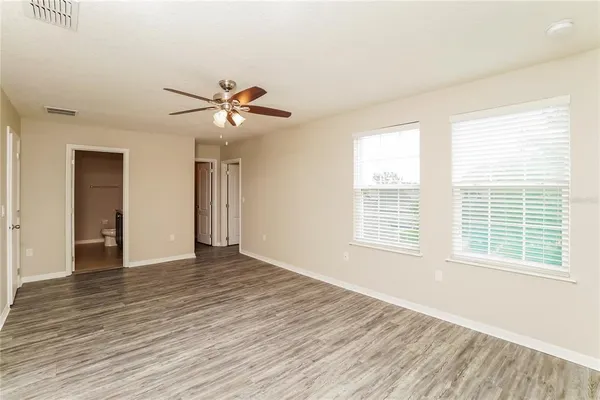 a view of an empty room with a window and a ceiling fan