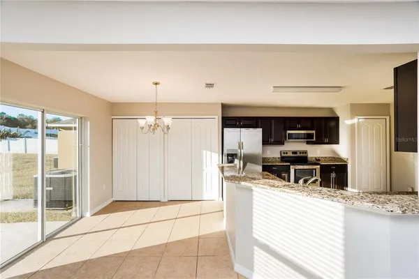 a kitchen with stainless steel appliances kitchen island granite countertop a refrigerator and a stove top oven