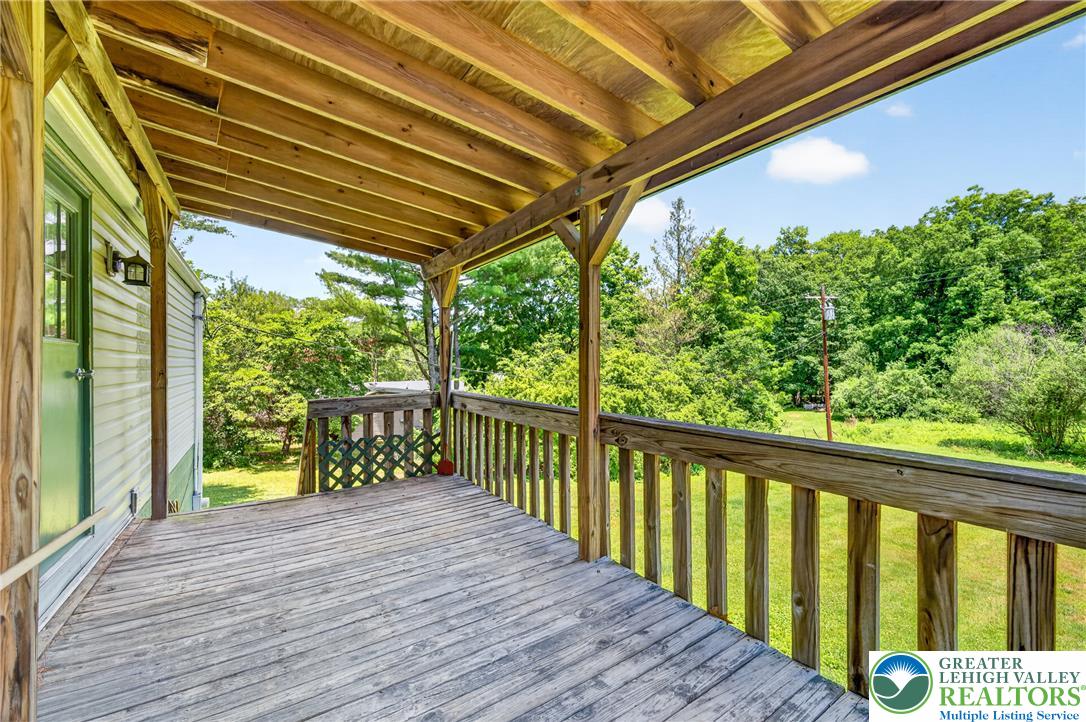 2674 Williams Road Danielsville, PA 18038 - Photo 5 of 31 A spacious covered wooden deck overlooks a verdant landscape, perfect for outdoor enjoyment.