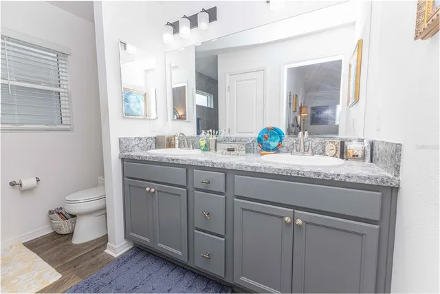 a spacious bathroom with double vanity and a mirror