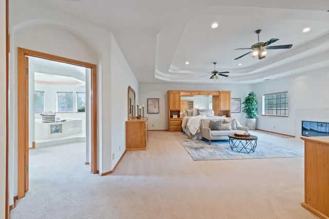 a view of an empty room with window cabinet flat screen tv and ceiling fan