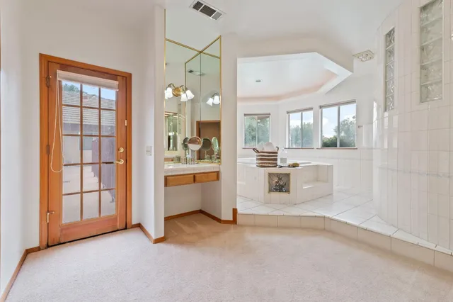 an empty room with a chandelier fan and windows
