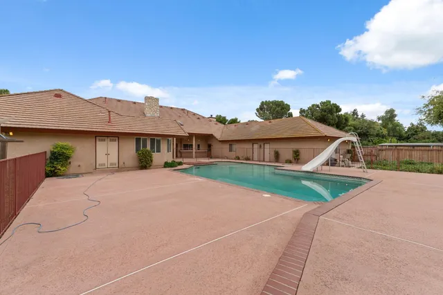 an aerial view of residential houses with outdoor space and trees