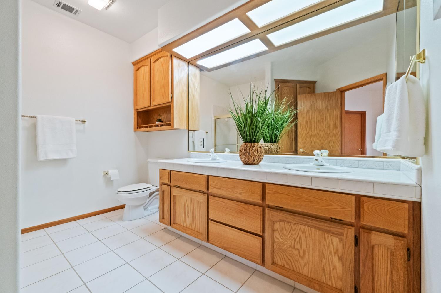 7357 East Dennett Avenue Fresno, CA 93737 - Photo 44 of 84 a bathroom with a granite countertop sink and a mirror