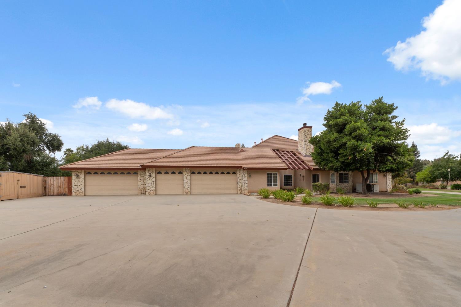 7357 East Dennett Avenue Fresno, CA 93737 - Photo 67 of 84 a front view of a house with a yard and trees
