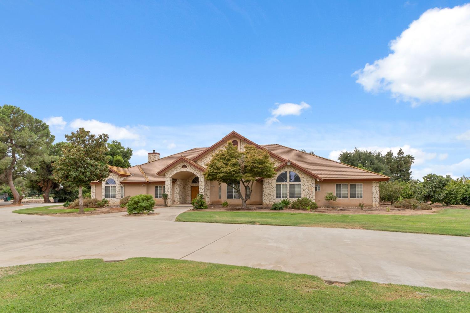 7357 East Dennett Avenue Fresno, CA 93737 - Photo 70 of 84 a front view of a house with a garden and yard