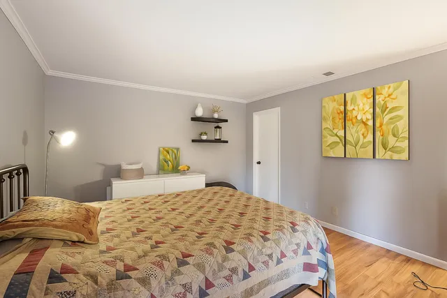 a bedroom with a bed and painting on the wall