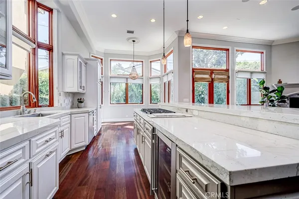 a kitchen with stainless steel appliances granite countertop a stove a refrigerator and a window with wooden floors