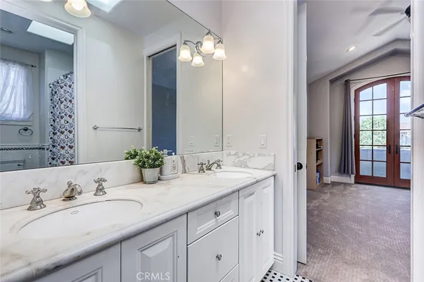 a spacious bedroom with a bed a mirror and a window