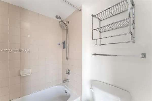 a bathroom with a shower toilet and tub