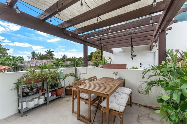 a view of a patio with table and chairs potted plants with wooden floor