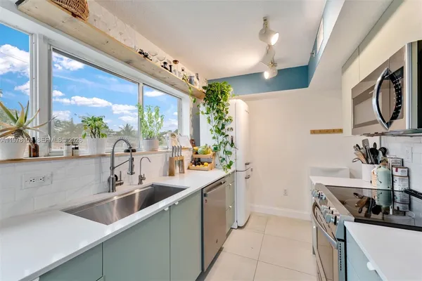 a kitchen with stainless steel appliances a sink a stove and a microwave