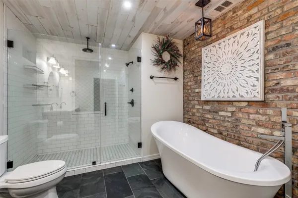 a bathroom with a sink vanity granite toilet and a shower