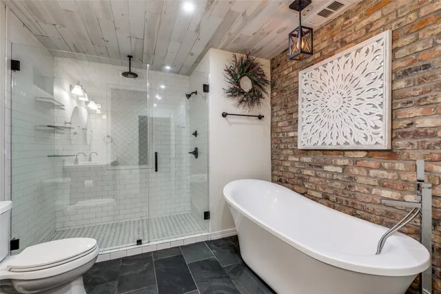 a bathroom with a sink vanity granite toilet and a shower