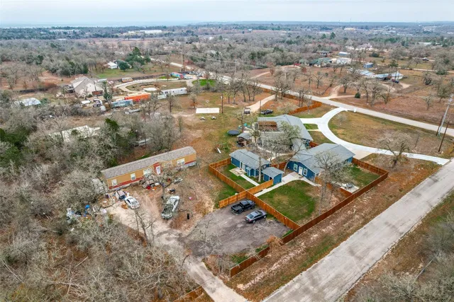 a kitchen with stainless steel appliances a stove top oven a sink dishwasher a refrigerator and white cabinets with wooden floor