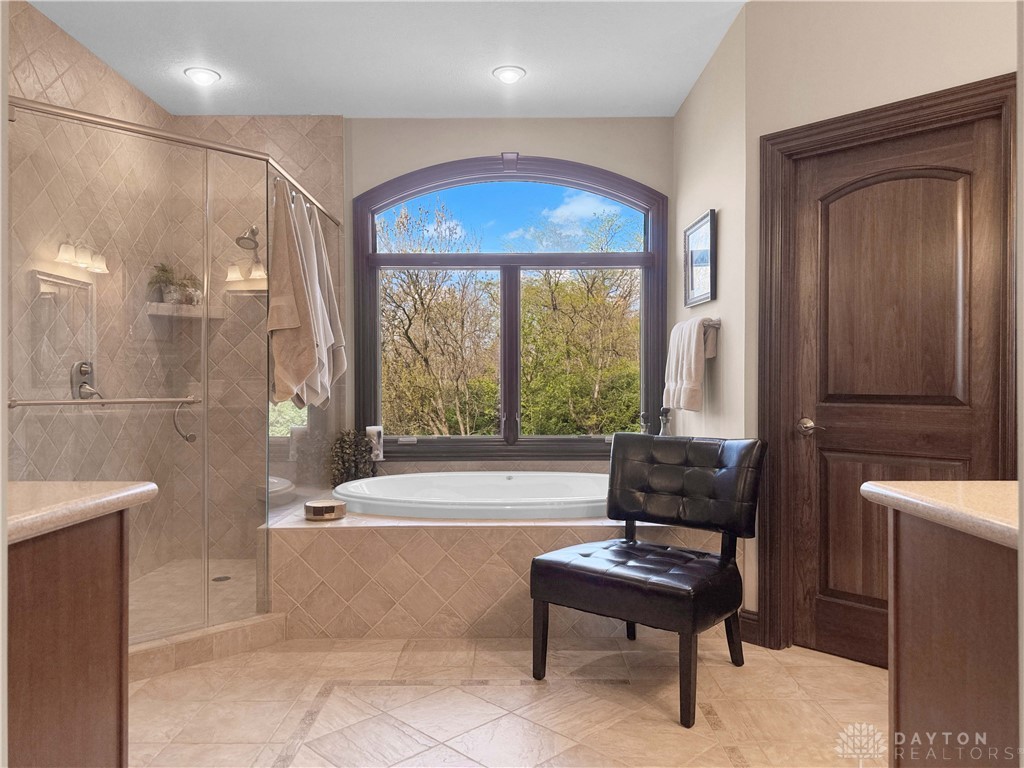 4096 Middle Urbana Road Urbana, OH 43078 - Photo 4 of 96 This primary bathroom offers a glass-enclosed shower, a large soaking tub, and ample natural light.
