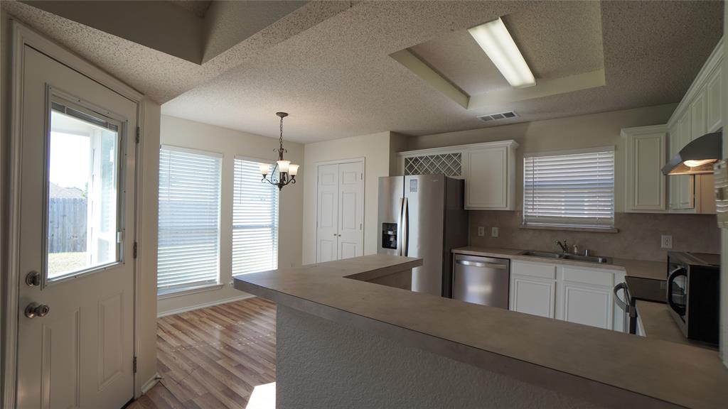 137 Magnolia Lane Rockwall, TX 75032 - Photo 8 of 28 a kitchen with stainless steel appliances granite countertop a refrigerator a sink and a stove