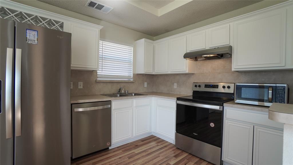 137 Magnolia Lane Rockwall, TX 75032 - Photo 10 of 28 a kitchen with stainless steel appliances granite countertop a refrigerator sink and stove