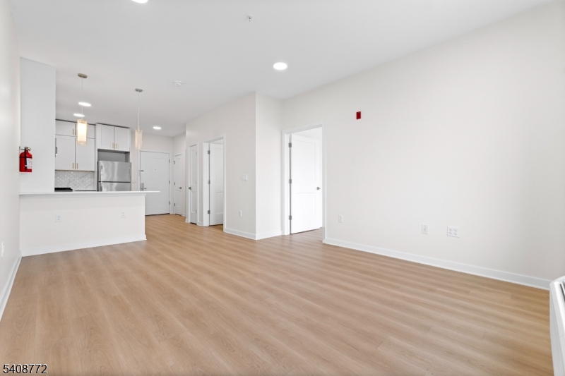 321 East 3rd Street, Unit 210 Plainfield, NJ 07060 - Photo 12 of 43 a view of a kitchen with kitchen island a sink wooden floor and a refrigerator
