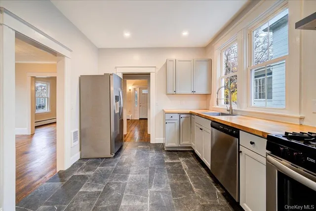 a view of an empty room with wooden floor and windows
