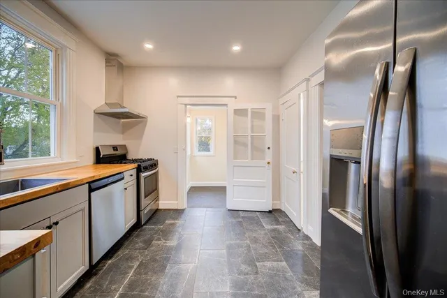 a large kitchen with stainless steel appliances a window and a refrigerator
