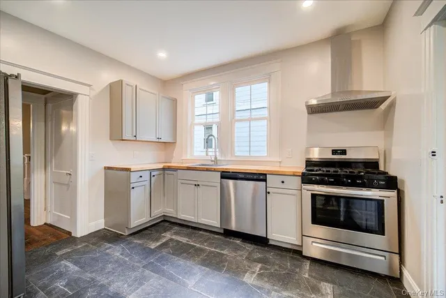 a kitchen with granite countertop white cabinets and stainless steel appliances