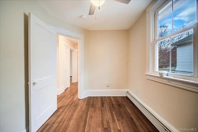 a view of a room with wooden floor and window