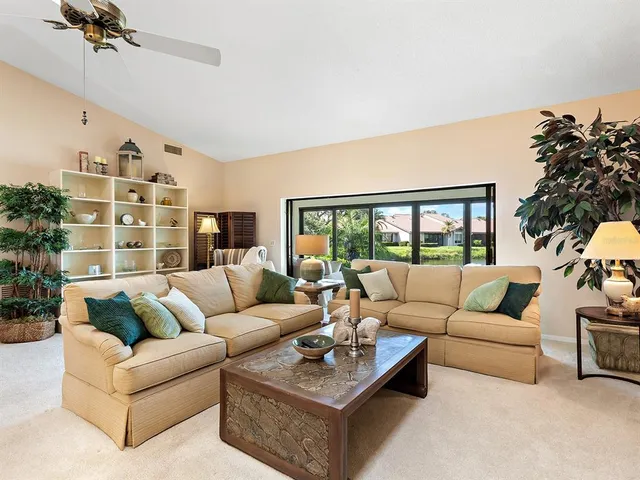 a living room with furniture flower pot and a flat screen tv