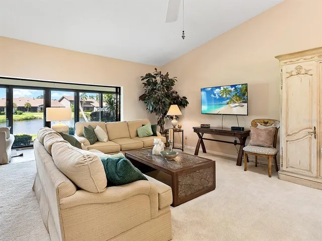 a living room with furniture a chandelier and a dining table