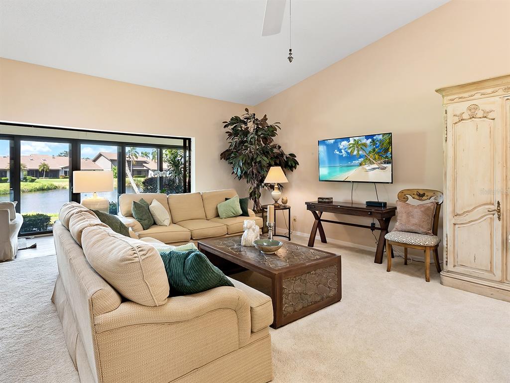 6094 Wilshire Boulevard, Unit 8 Sarasota, FL 34233 - Photo 12 of 42 a living room with furniture flower pot and a flat screen tv