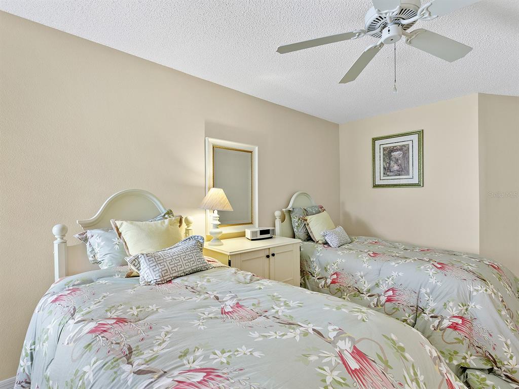 6094 Wilshire Boulevard, Unit 8 Sarasota, FL 34233 - Photo 16 of 42 a bedroom with bed and a chandelier