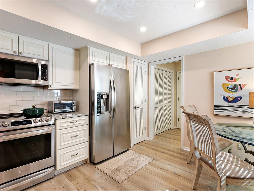 6094 Wilshire Boulevard, Unit 8 Sarasota, FL 34233 - Photo 28 of 42 a kitchen with stainless steel appliances granite countertop a stove microwave and refrigerator