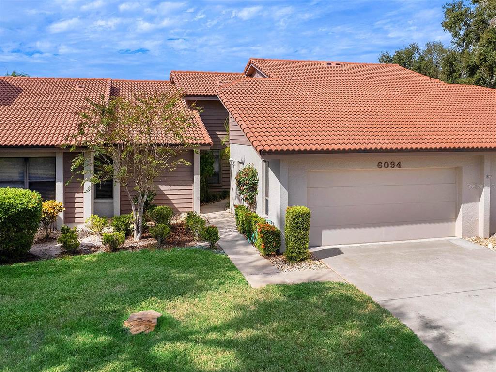 6094 Wilshire Boulevard, Unit 8 Sarasota, FL 34233 - Photo 30 of 42 a front view of a house with a garden and plants