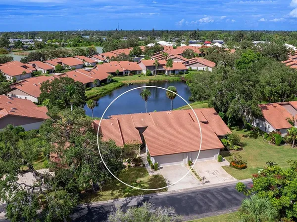 an aerial view of residential houses with outdoor space and trees