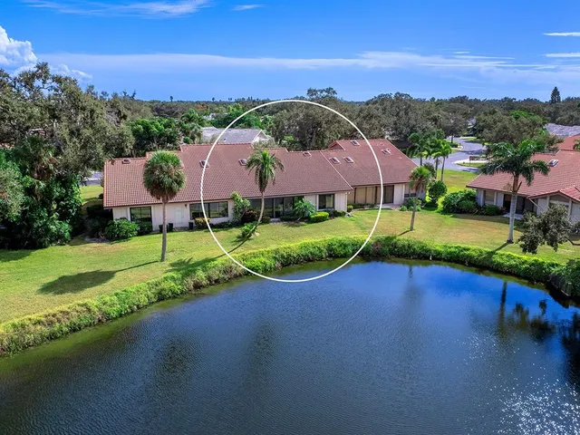 an aerial view of a tennis ground and a cars park side of the road
