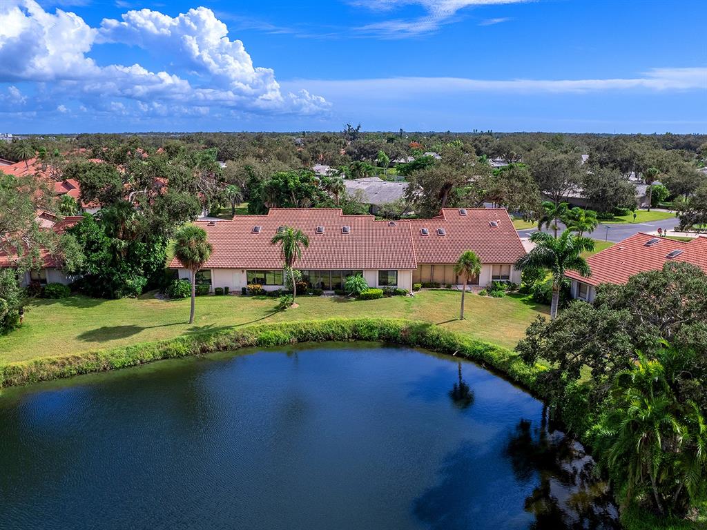 6094 Wilshire Boulevard, Unit 8 Sarasota, FL 34233 - Photo 36 of 42 a view of a lake with houses in the back