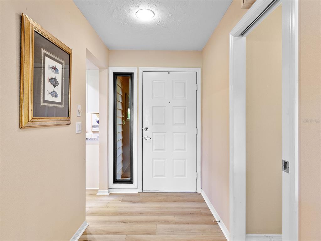 6094 Wilshire Boulevard, Unit 8 Sarasota, FL 34233 - Photo 4 of 42 a view of a hallway with wooden floor and entryway