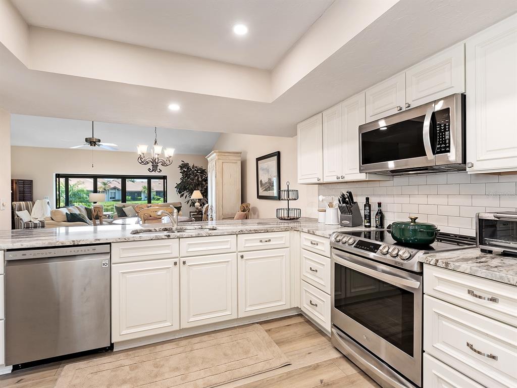 6094 Wilshire Boulevard, Unit 8 Sarasota, FL 34233 - Photo 5 of 42 a kitchen with a sink stove and microwave