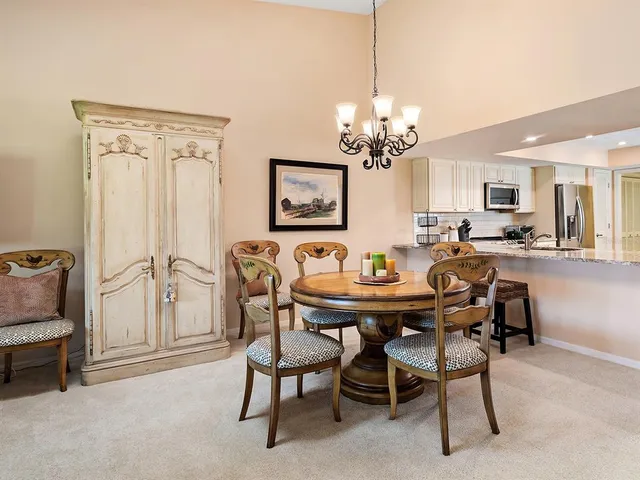 a room with kitchen island and white cabinets