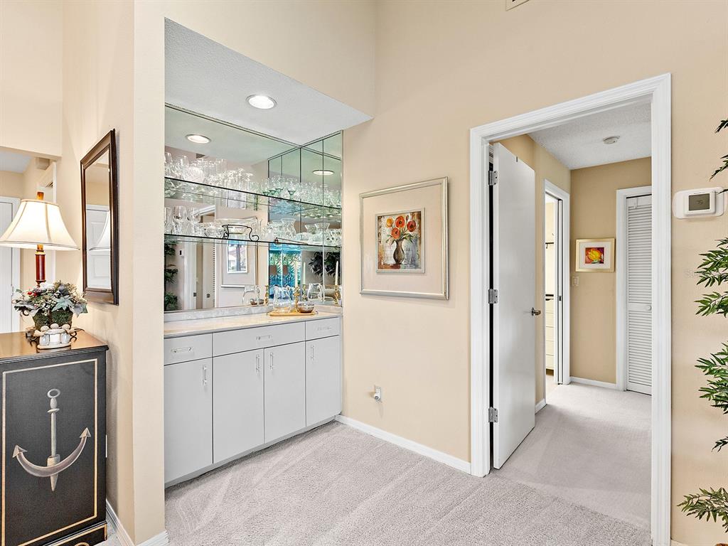 6094 Wilshire Boulevard, Unit 8 Sarasota, FL 34233 - Photo 10 of 42 a room with kitchen island and white cabinets