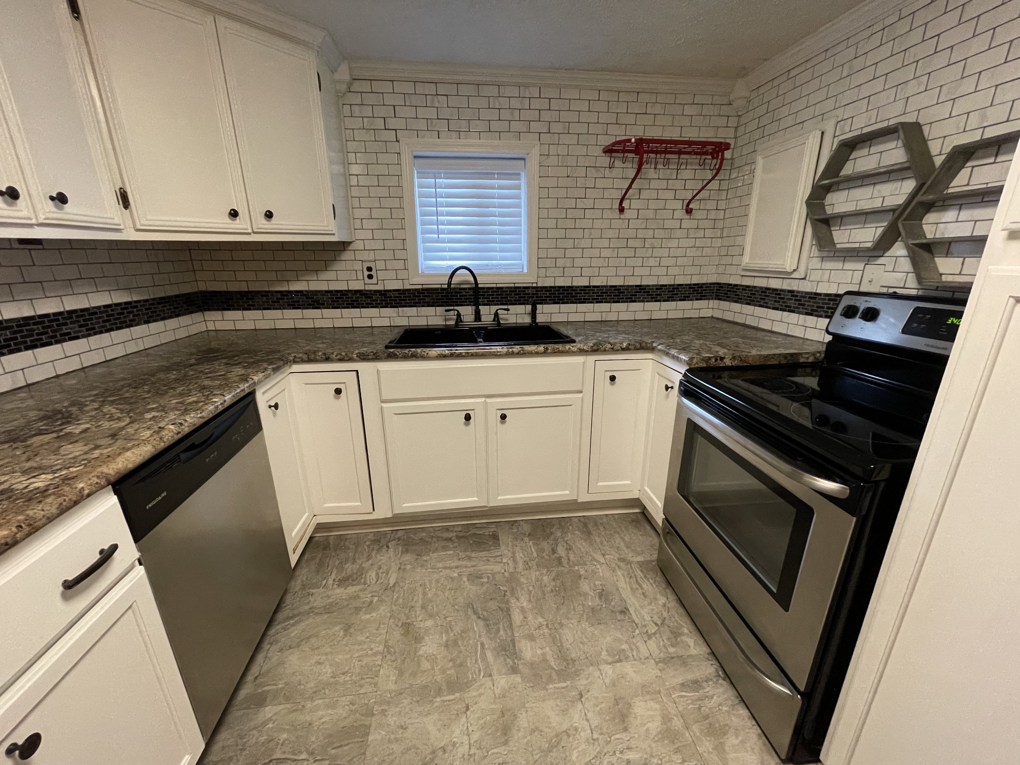 312 Gentry Street Tullahoma, TN 37388 - Photo 6 of 29 a kitchen with granite countertop a sink a stove and cabinets