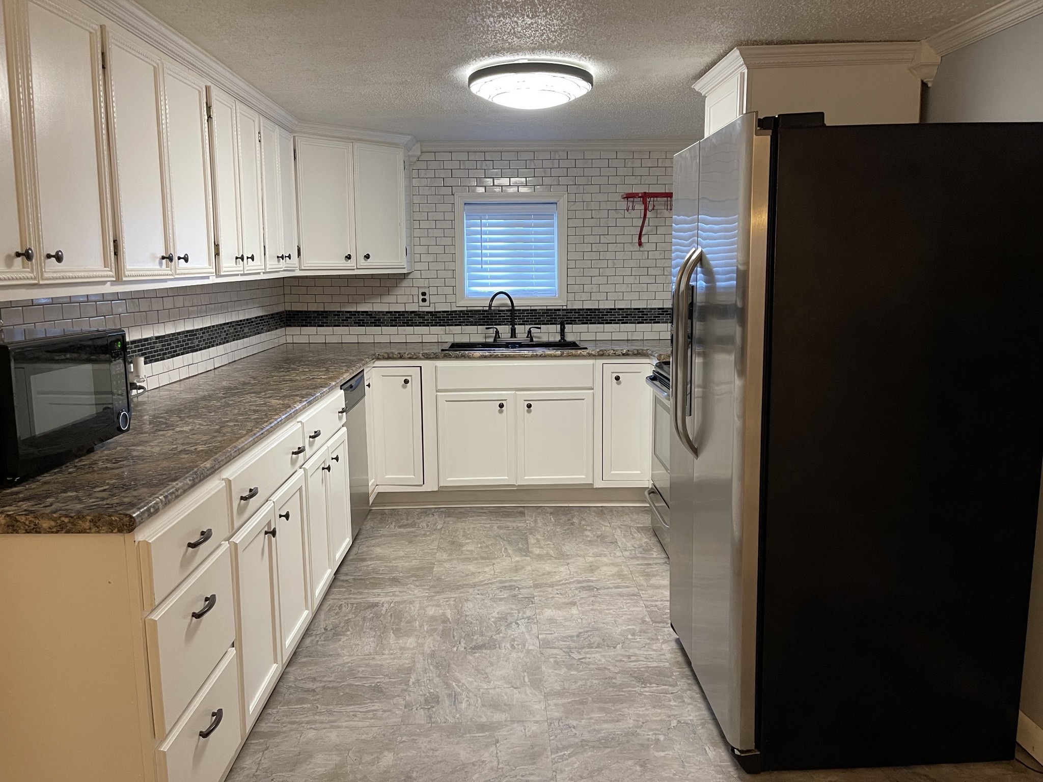 312 Gentry Street Tullahoma, TN 37388 - Photo 7 of 29 a large kitchen with granite countertop a refrigerator and a sink