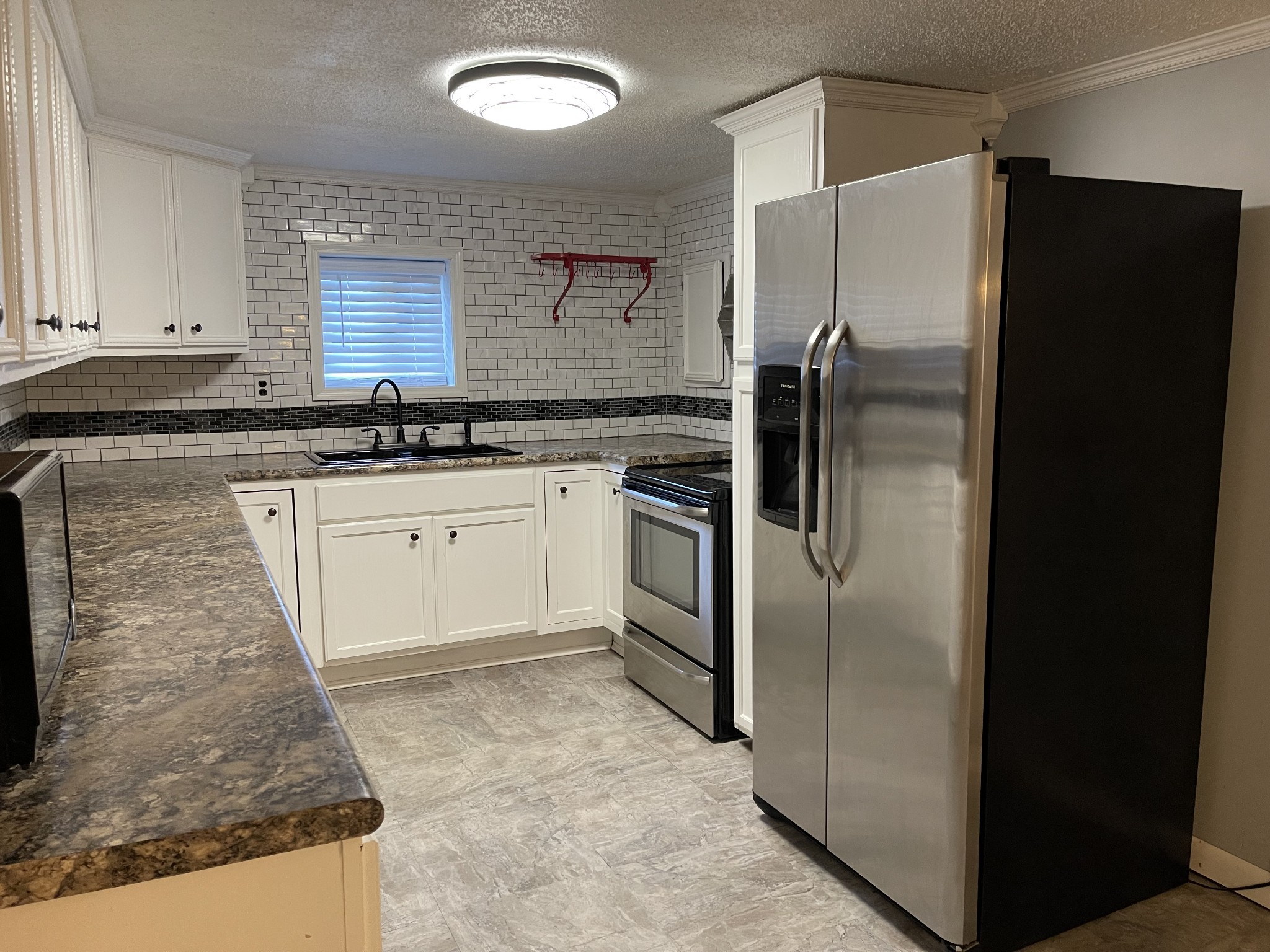 312 Gentry Street Tullahoma, TN 37388 - Photo 8 of 29 a kitchen with granite countertop a refrigerator and a sink