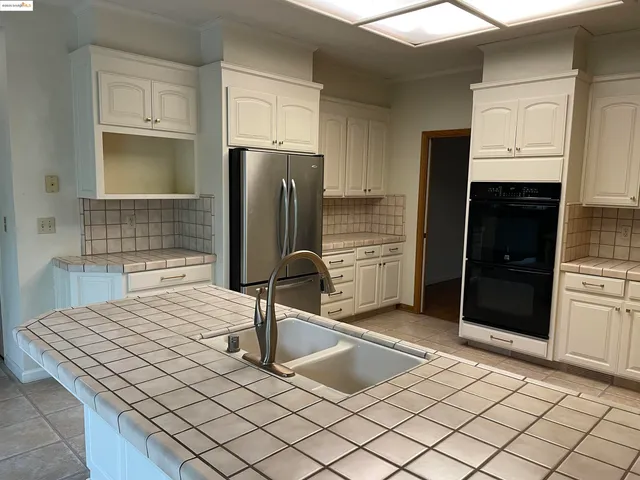 a kitchen with white cabinets stainless steel appliances and sink